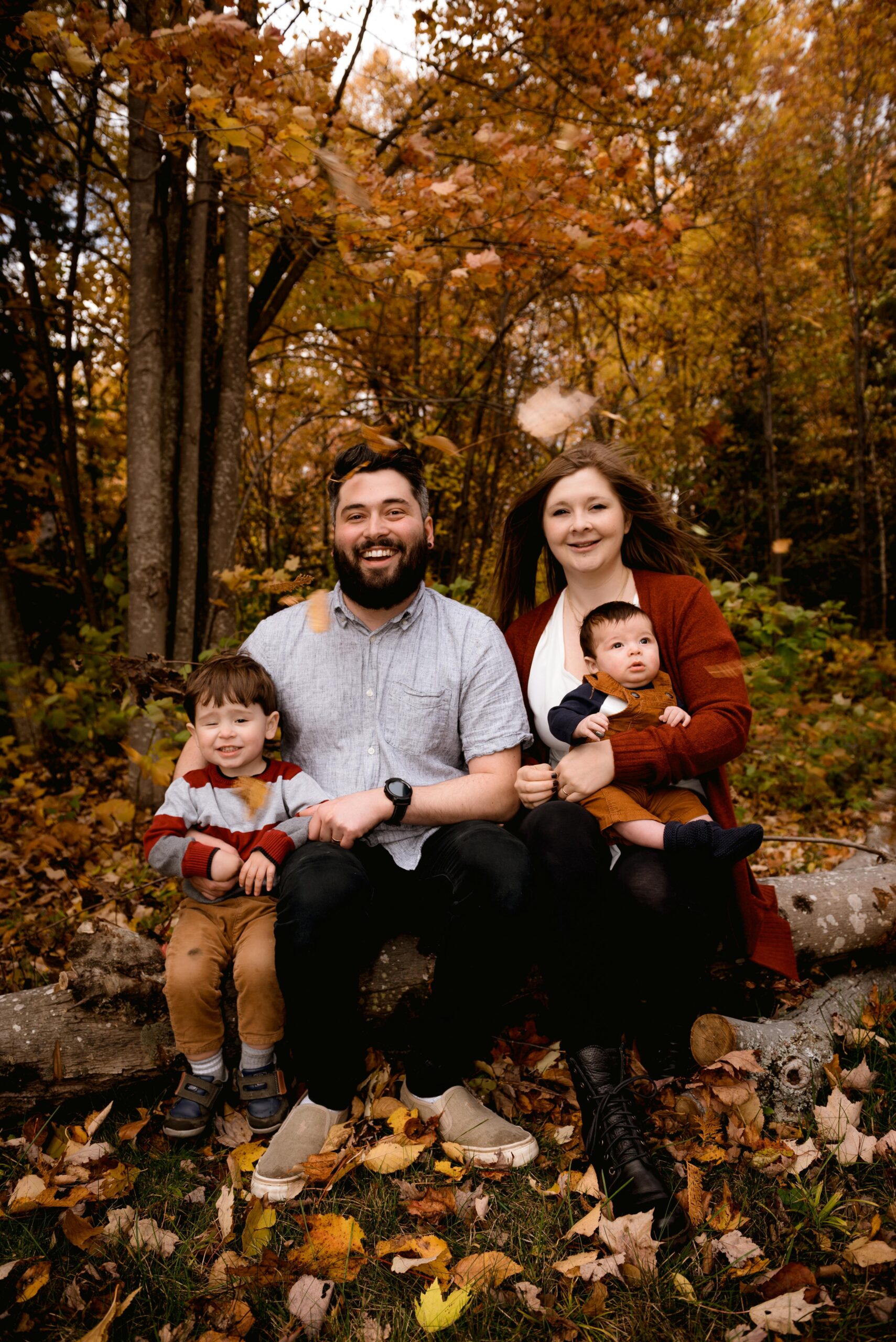 Family in coordinating fall outfits in a grassy field