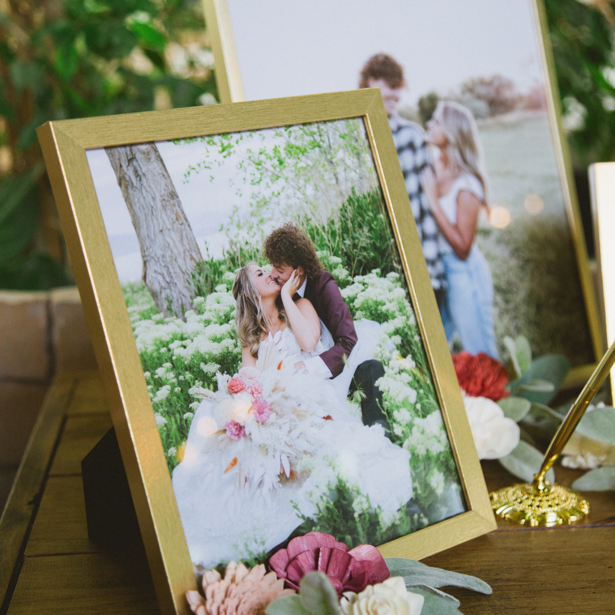 Framed wedding photos staggered on a table